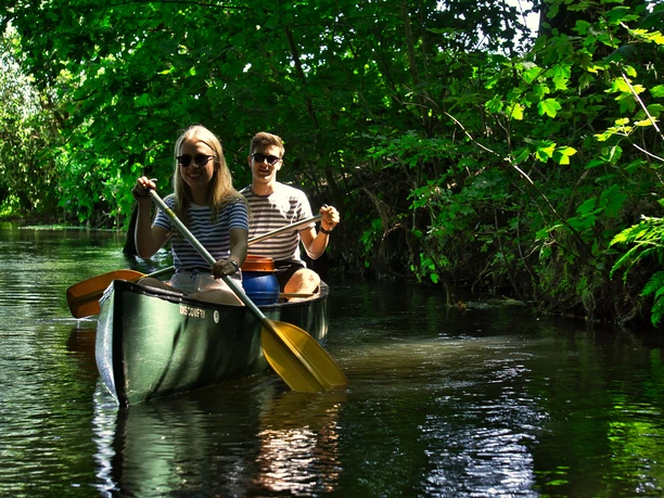 Kanu fahren auf der Luhe Zwei Menschen in einem Kanu genießen die Fahrt auf dem von Bäumen gesäumten Fluss.