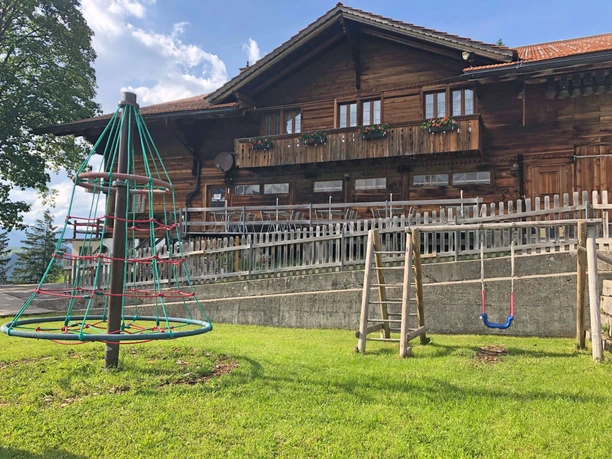 Aire de jeux Gsässweid avec balançoire et carrousel Aire de jeux avec carrousel de cordes et balançoire, restaurant en arrière-plan