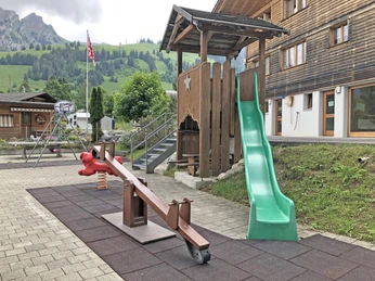 Aire de jeux avec bascule et toboggan Kinderspielplatz mit grüner Rutschbahn und WippeChildren's playground with green slide and seesawAire de jeux pour enfants avec toboggan vert et bascule