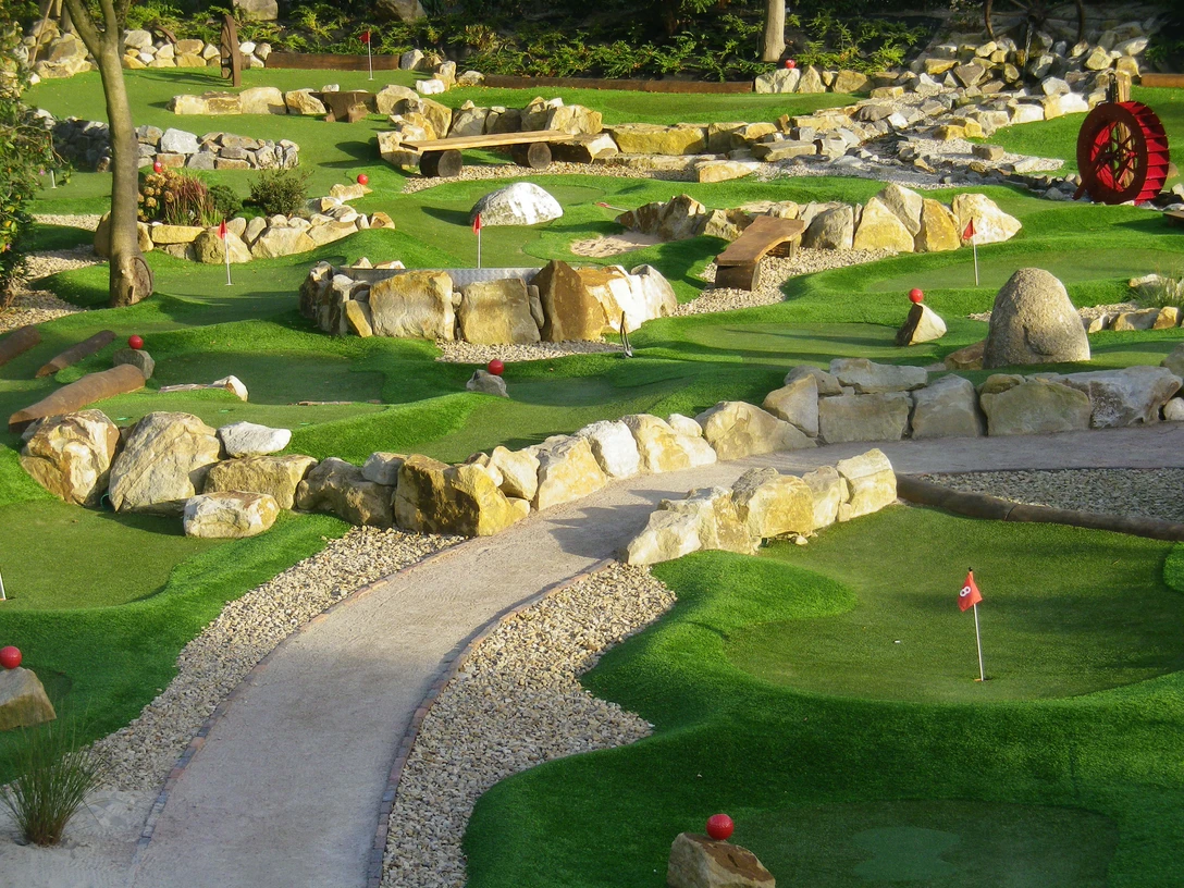 janßen-hof-rastede_abenteuergolfen Miniaturgolfplatz in Rastede mit Steinlandschaft und Fahnen.Miniature golf course in Rastede with stone landscape and flags.
