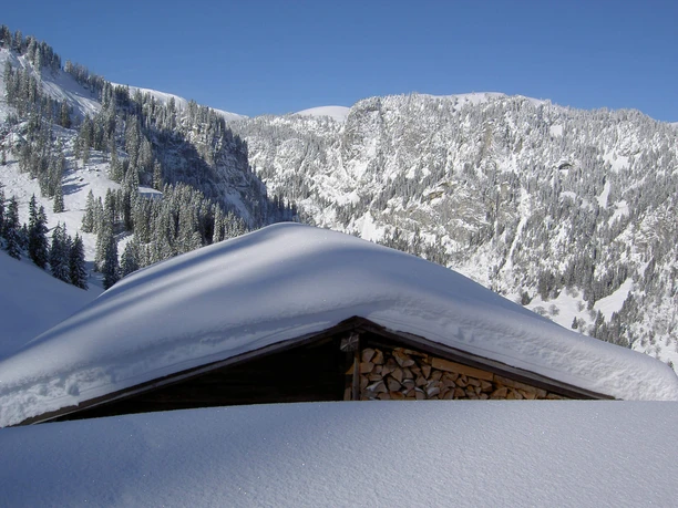 Toit d'un chalet d'alpage, recouvert d'une épaisse couche de neige