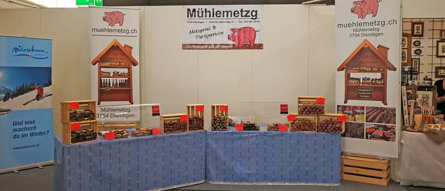 Mühlemetzg butcher's shop Exhibition stand with tables, blue tablecloths and stacked sausages