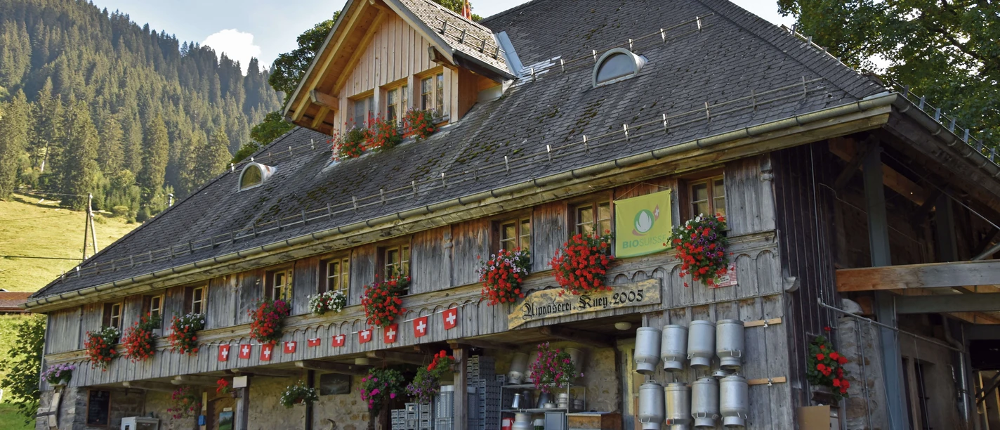 Fromagerie d'alpage «Kiley» Bâtiment de la fromagerie d'alpage avec des géraniums aux fenêtres
