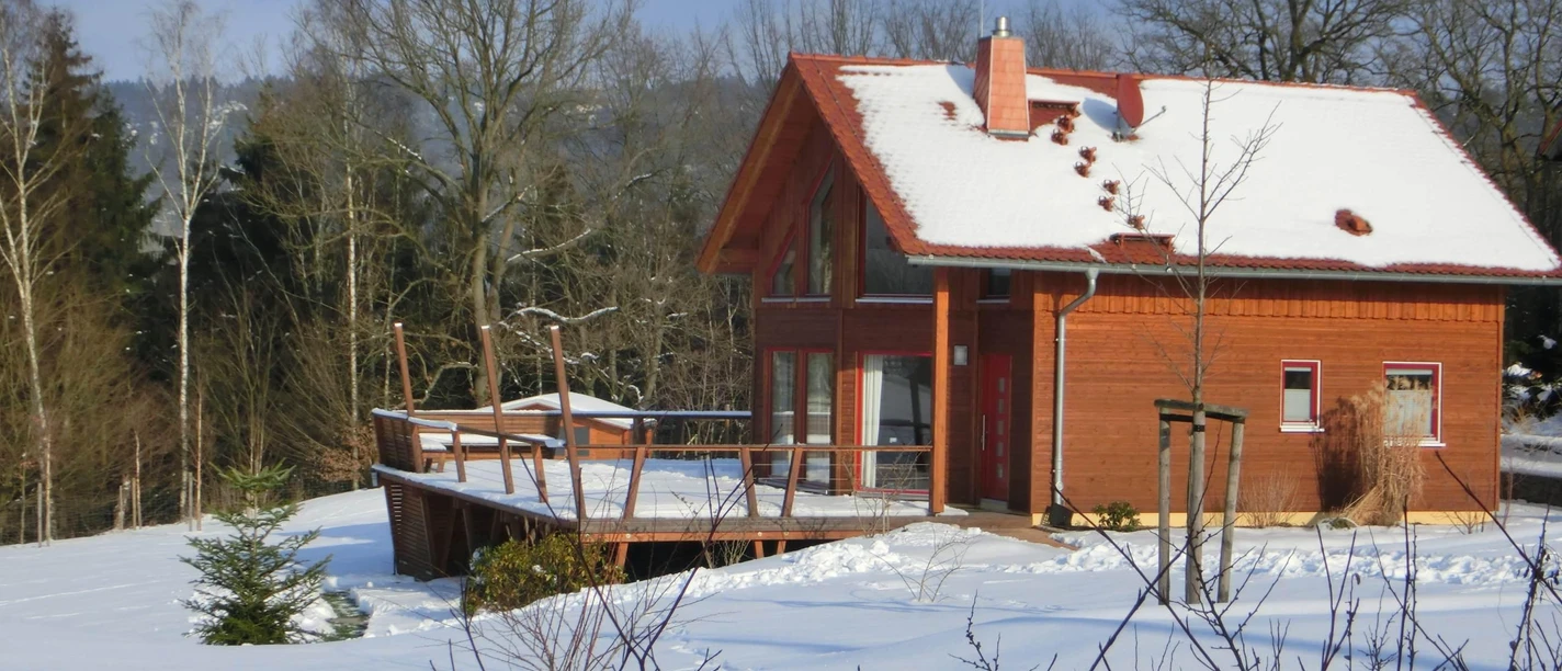 Das Ferienhaus im Winterkleid mit Rodelberg