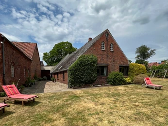 Im Garten Blick vom weitläufigen Garten mit Klettergerüst für Kinder und Sonnenliegen für die Erwachsenen auf das bäuerliche Ferienhaus.View of the farmhouse from the spacious garden with climbing frame for children and sun loungers for adults.Udsigt fra den rummelige have med klatrestativ til børn og liggestole til voksne til det rustikke feriehus.Uitzicht vanuit de ruime tuin met klimrek voor kinderen en ligstoelen voor volwassenen op het rustieke vakantiehuis.