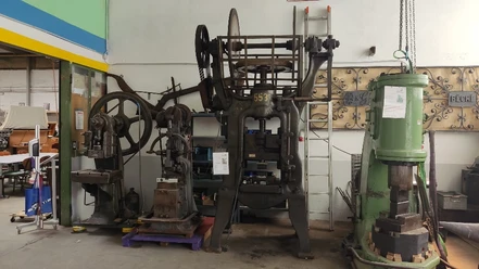 Die Krachmacher im Eingangsbereich v. links= Excenterpresse/Schwinghammer/Reib-Spindelpresse/Bêché-Hammer Historische Maschinen und Pressen in einer Werkstatt, darunter ein älteres Modell mit massiven Zahnrädern.