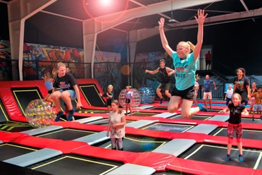 Das Bild zeigt die Halle mit Trampolinen und springenden Kindern