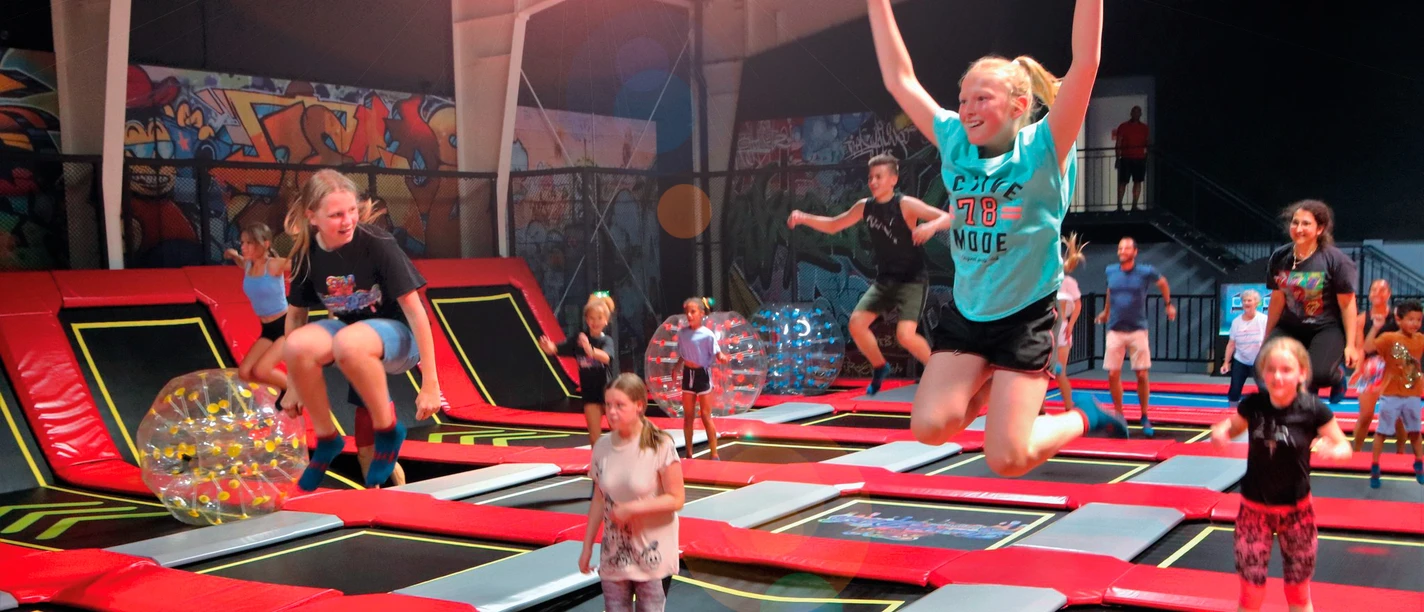 Das Bild zeigt die Halle mit Trampolinen und springenden Kindern