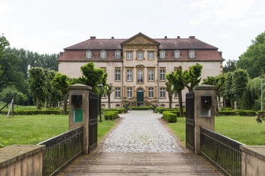 Schloss Möhler Historisches Herrenhaus mit symmetrischer Fassade, umgeben von gepflegtem Garten und Kiesweg.