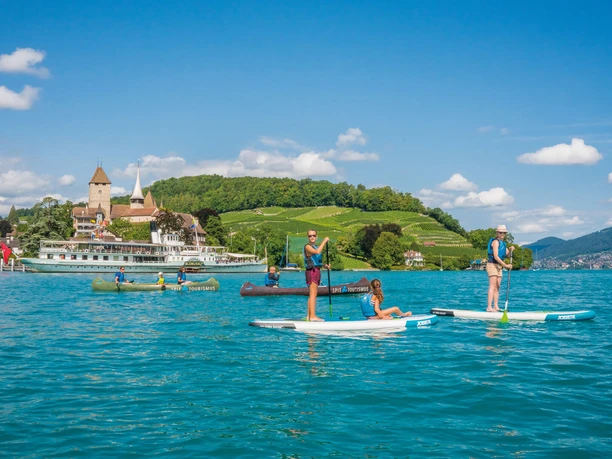 spiez-kanuweg-thunersee-sommer-bucht-schloss-rebberg-gruppe-spass-boot-pedalo