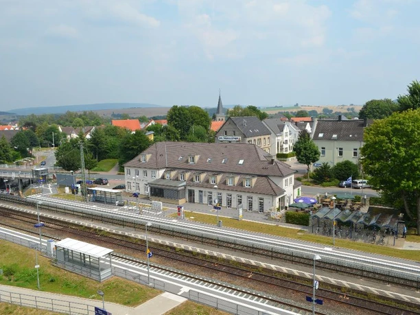 Luftaufnahme des Bahnhofs Steinheim, umgeben von grüner Landschaft und mehreren Gebäuden.