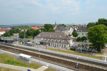Bahnhof Steinheim Luftaufnahme des Bahnhofs Steinheim, umgeben von grüner Landschaft und mehreren Gebäuden.