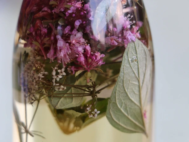 A glass bottle filled with vinegar and herbs