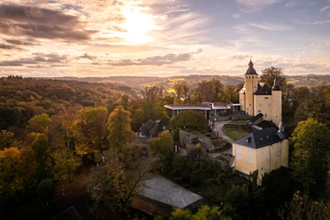 Schloss Homburg Blick auf Schloss Homburg bei Nümbrecht, umgeben von bunten Herbstwäldern unter dramatischen Wolkenhimmel.