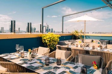 The Blasky Rooftop - Roof terrace Set table with glasses on rooftop terrace, skyline in the background.