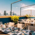 The Blasky Rooftop - Roof terrace Set table with glasses on rooftop terrace, skyline in the background.