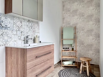 Badezimmer Modernes Badezimmer mit hölzernem Waschbeckenunterschrank, beleuchtetem Spiegel und stilvollem Fliesenmuster.