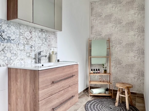 Badezimmer Modernes Badezimmer mit hölzernem Waschbeckenunterschrank, beleuchtetem Spiegel und stilvollem Fliesenmuster.