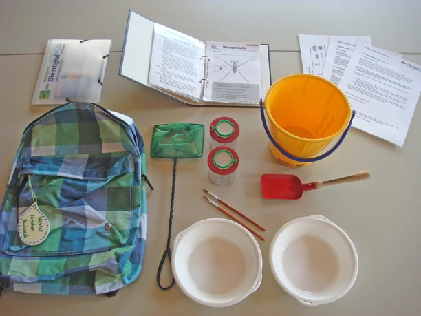 Un sac à dos, un filet de capture, une loupe à godet et bien d'autres choses encore, disposés sur une table