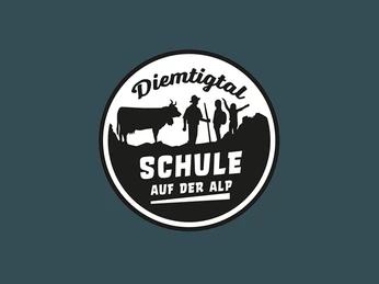 Logo School on the Alp Schwarz-weisses Logo auf grünem Hintergrund. Schriftzug: Diemtigtal - Schule auf der AlpBlack and white logo on a green background. Lettering: Diemtigtal - School on the AlpLogo noir et blanc sur fond vert. Inscription : Diemtigtal - L'école sur l'alpage