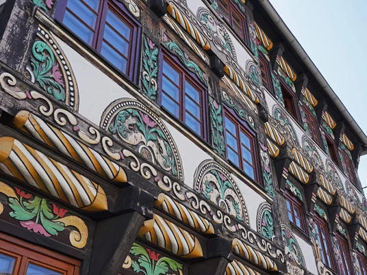 Detailaufnahme von farbigem Schnitzwerk an historischem Fachwerkhaus