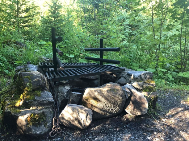 A barbecue area built from stones with an adjustable grill