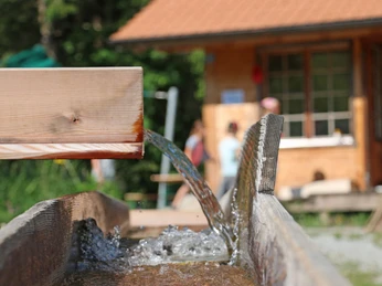 Fliessendes Wasser im Kännelsystem Wasser läuft von einem Holzkännel in den anderenWater runs from one wooden jug into the otherL'eau coule d'une louche en bois à l'autre