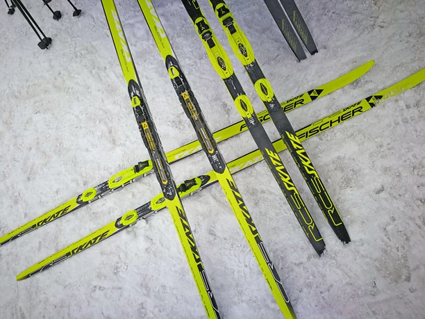 The cross-country skis ready for action Yellow cross-country skis lie crossed over each other on the snow-covered ground