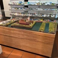 Ein detailreiches Schlossmodell, geschützt von einer Plexiglasvitrine, steht in einem Informationszentrum.