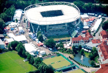Luftaufnahme des Gerry Weber Stadions in Halle Westfalen, umgeben von Tennisplätzen und Grünflächen.