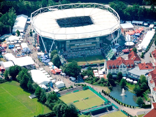 Luftaufnahme des Gerry Weber Stadions in Halle Westfalen, umgeben von Tennisplätzen und Grünflächen.