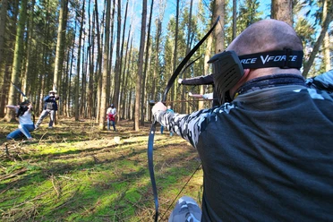 3D Bogenpark Surwold Gruppe mit Bögen zielt im Wald beim 3D Bogenpark Surwold auf Ziele zwischen hohen Bäumen.