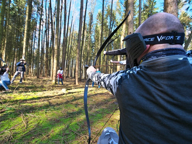 3D Bogenpark Surwold Gruppe mit Bögen zielt im Wald beim 3D Bogenpark Surwold auf Ziele zwischen hohen Bäumen.
