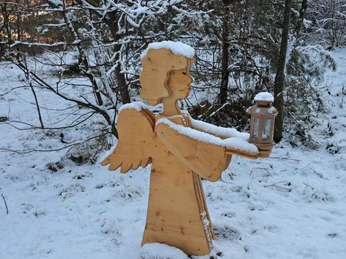 L'ange en bois éclaire le chemin avec sa lanterne
