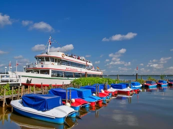 boote-weisse-flotte Ein weißes Ausflugsschiff der Weißen Flotte liegt am Steg, umgeben von farbenfrohen Freizeitbooten.A white excursion boat from the White Fleet is moored at the jetty, surrounded by colorful leisure boats.En hvid udflugtsbåd fra Den Hvide Flåde ligger fortøjet ved anløbsbroen, omgivet af farverige fritidsbåde.Een witte excursieboot van de Witte Vloot ligt aangemeerd aan de steiger, omringd door kleurrijke plezierboten.