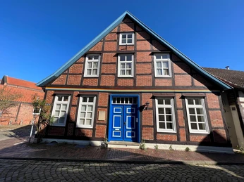 Wilhelm-Siebert-Haus Historisches Fachwerkhaus mit markanter blauer Tür und Ziegelsteinfassade unter strahlend blauem Himmel.