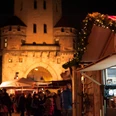 VeedelsAdvent on the Chlodwigplatz Weihnachtsmarkt bei Nacht, geschmückte Stände, rot-weiß gestreifte Dächer, beleuchtete Severinstorburg.Christmas market at night, decorated stalls, red and white striped roofs, illuminated Severinstorburg.