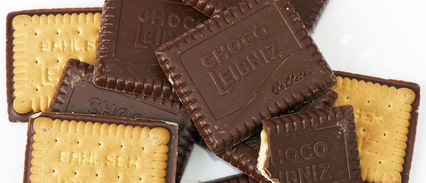 Butterkekse mit einseitiger Schokoladenglasur, auf der "Choco Leipniz" steht, liegen neben- und übereinander.