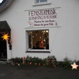 Fenstermusik - Adventsfest Eine festliche Dekoration umgibt ein Fenster, aus dem sanfte Musik tönt, mit Kerzenlichtern und Sternen.