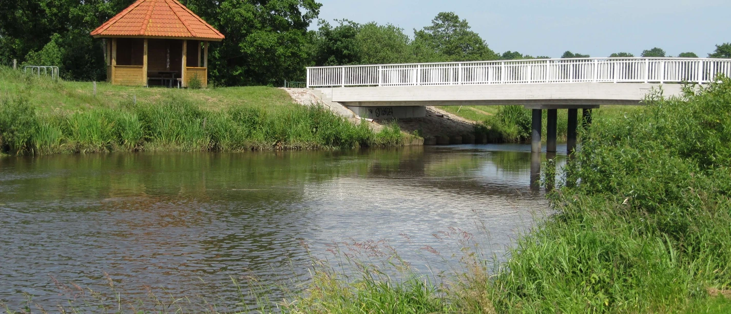Rastplatz Bokeler Brücke Ruhiger Rastplatz an der Bokeler Brücke mit Blick auf das Aper Tief, umgeben von grünen Wiesen und einem kleinen Pavillon.