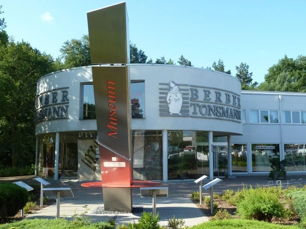 Außenansicht des Teppich-Museums Tönsmann mit moderner Architektur und umgeben von Grünflächen.