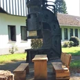 Schmiedehammer am Rastplatz Auf dem Bild ist ein historischer Schmiedehammer zu sehen, der als Rastplatz mit Sitzbänken dient.