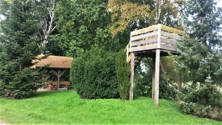 Rastplatz Bokelermoor mit Aussichtsturm Ein gemütlicher Rastplatz mit Holzaussichtsturm, umgeben von grünen Bäumen und einem überdachten Sitzbereich.