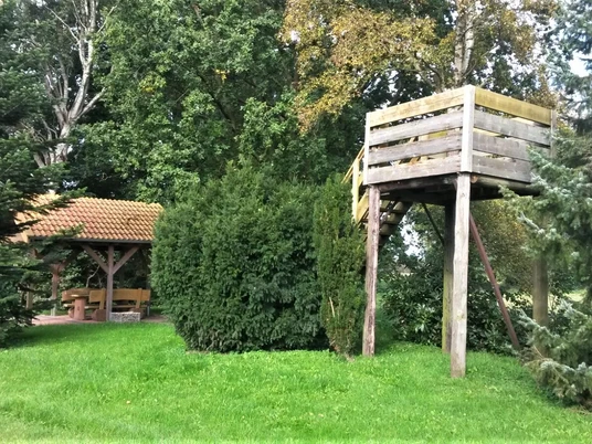 Rastplatz Bokelermoor mit Aussichtsturm Ein gemütlicher Rastplatz mit Holzaussichtsturm, umgeben von grünen Bäumen und einem überdachten Sitzbereich.