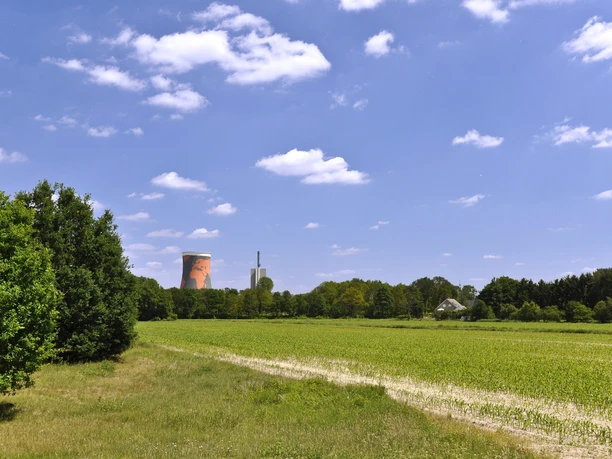 Kühlturm in Meppen-Hüntel Weite Wiesenlandschaft bei Meppen mit markant bemaltem Kühlturm und blauem Himmel im Hintergrund.
