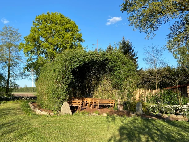Weidenkirche Börger Grüne Weidenkirche in Börger mit naturgewölbtem Dach und Holzbänken unter blauem Himmel