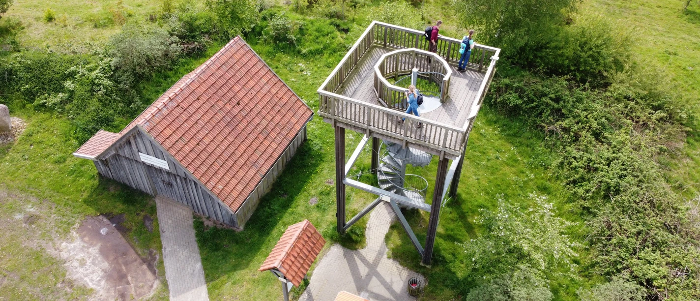 Niederlangen Kapellenmoorgraben Aussichtsturm aus Holz mit Wendeltreppe am Kapellenmoorgraben, umgeben von Grün und Spaziergängern.