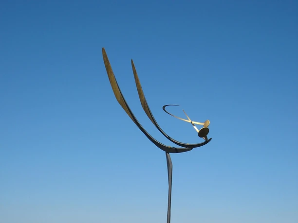 Tanz der Winde mit Insel Wilhelmstein im Hintergrund Eine elegante Windskulptur erhebt sich vor dem Steinhuder Meer, mit Wilhelmstein im Hintergrund.