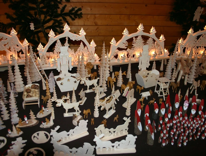 handwerkshuette22 Holzkunst mit beleuchteten Schwibbögen, geschnitzten Figuren und kleinen Weihnachtsmotiven.