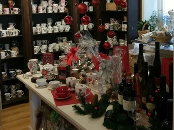 dat-teehus-weihnachten Im Teehaus stehen dekorative Tassenregale mit weihnachtlichem Schmuck und weinroten Kugeln.